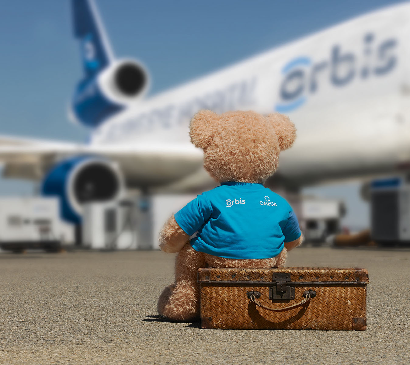 奥比斯泰迪熊吉祥物坐在奥比斯眼科飞行医院飞机旁边