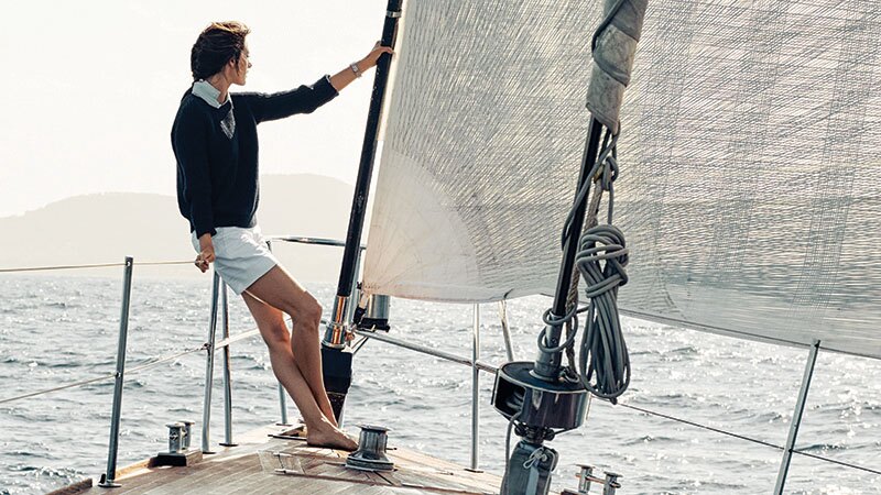 亚历山大·安布罗休坐在游艇船头安全扶杆上，欣赏地中海美景。